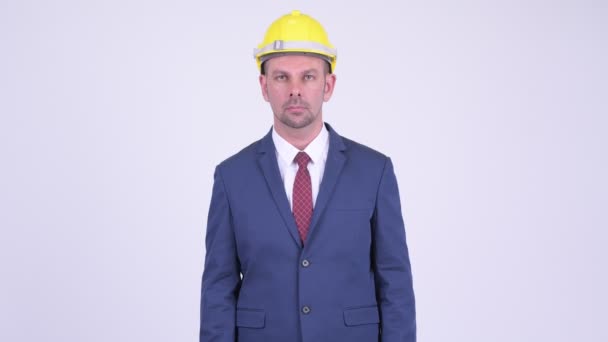 Happy businessman as engineer with arms crossed - Кадри, відео