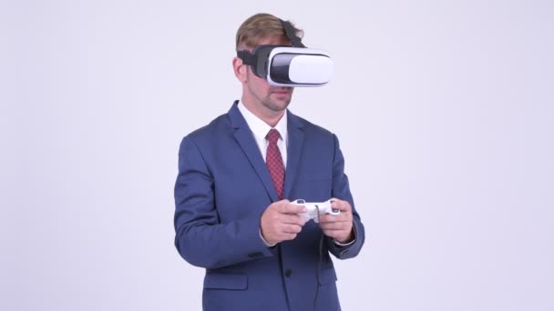 Blonde businessman playing games and using virtual reality headset - Footage, Video