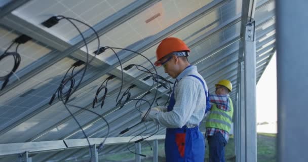 Workers connecting wires of solar panels - Filmmaterial, Video