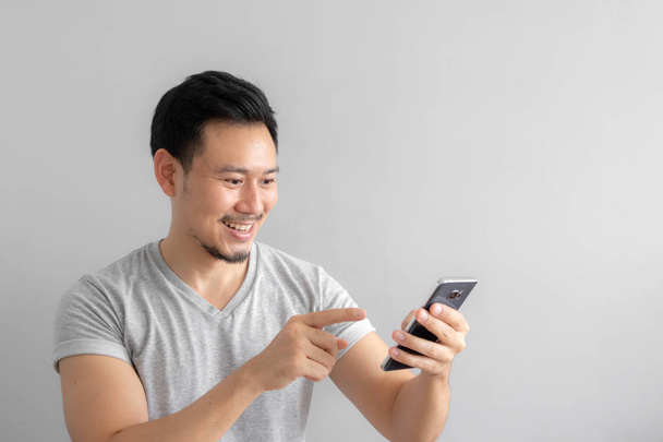 Smile and happy face of Asian man use and touch his smartphone. - Фото, изображение