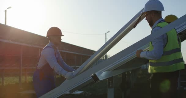 Drie werknemers installeren een zonnepaneel - Video