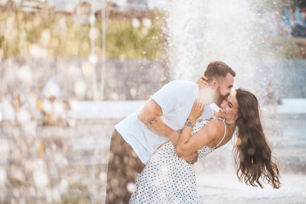 Przystojny facet i piękne dziewczyny Całowanie na tle fontanna - Zdjęcie, obraz