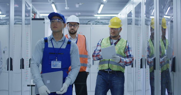 Elektrische werknemers lopen in de controlekamer - Video