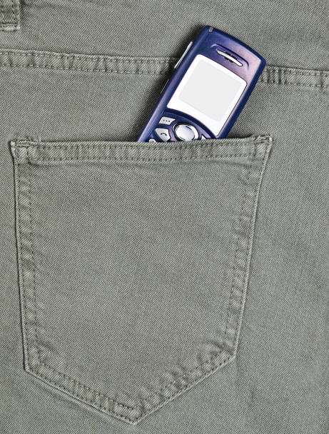 Παρωχημένες κουμπί τηλεφώνου με οθόνη για αντίγραφο χώρου στην πίσω τσέπη του τζιν πράσινο - Φωτογραφία, εικόνα