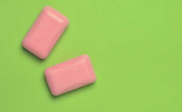 Dos piezas de jabón rosa sobre un fondo verde. Tendencia minimalista, vista superior, espacio para copiar
 - Foto, imagen