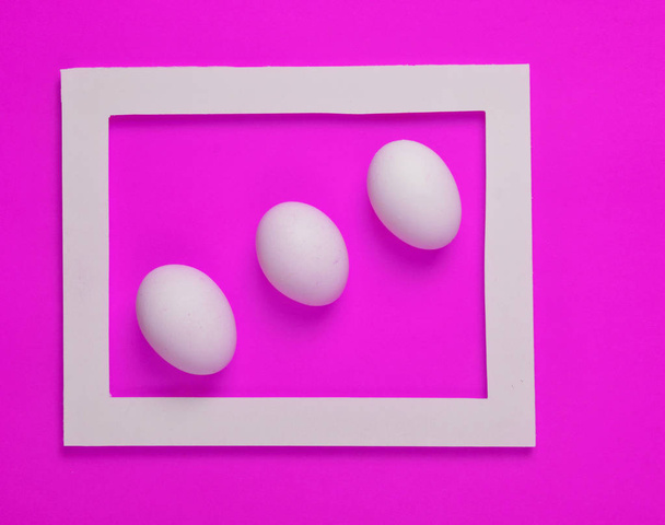 Tři Kuřecí vejce v bílém rámu na žlutém podkladu. Minimalistický trend - Fotografie, Obrázek