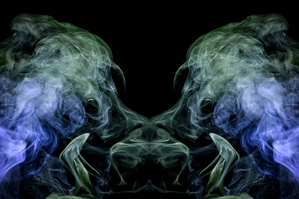 Fantasie print voor kleding: t-shirts, sweatshirts. Kleurrijke groen en blauw rook in de vorm van een schedel, monster, draak op een geïsoleerde zwarte achtergrond. Achtergrond van de rook van vap - Foto, afbeelding