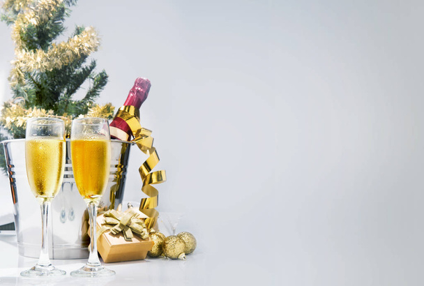 Wine bottle on ice bucket and a pair of glasses with christmas decoration. Party and celebration concept - Photo, Image