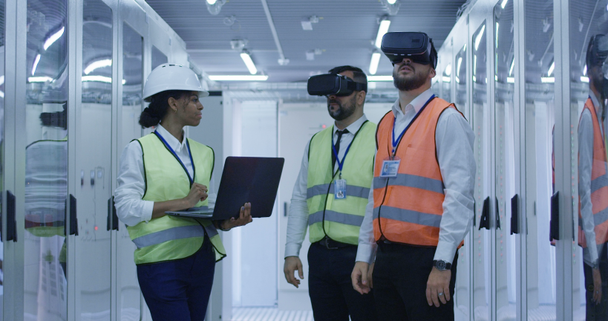 Trabajadores eléctricos en chalecos reflectantes utilizando VR
 - Imágenes, Vídeo