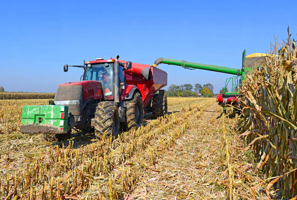 Kalusch, Ukraine 14. Oktober 2014: Moderner John Deere Traktor mit Anhänger zum Transport des Getreides zur Maisernte auf einem Feld in der Nähe der Stadt Kalusch, Westukraine - Foto, Bild