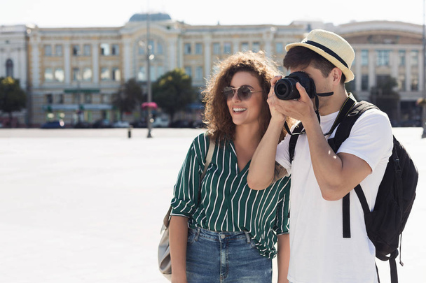 Tourist couple taking photos on camera on street - Foto, afbeelding
