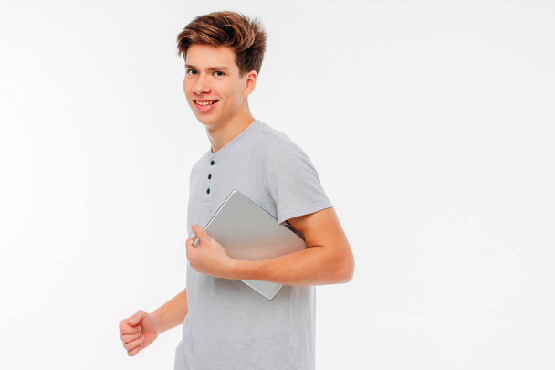 Attractive young man holding tablet in hands and smiling on white background - Φωτογραφία, εικόνα