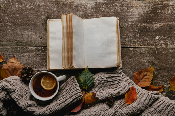 灰色のセーターとお茶、空白のノートブックや木製のテーブルの上の落ち葉フラット レイアウト - 写真・画像