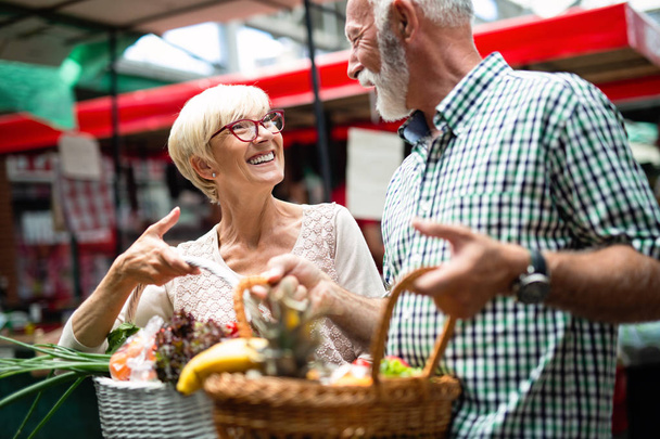 Senior happy shopping couple with basket on the market. Healthy diet. - Foto, Imagem
