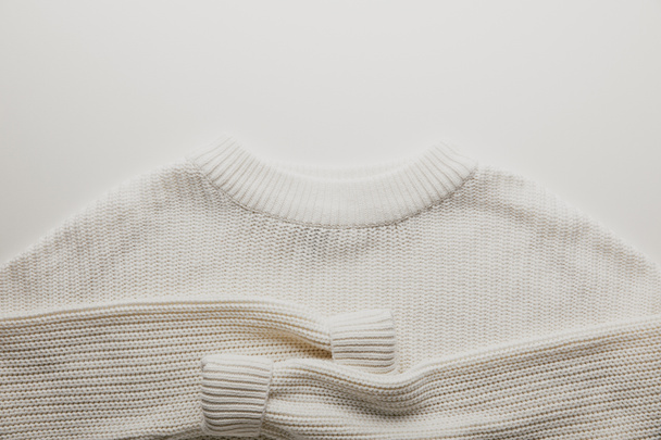 top view of white woolen sweater on white surface - Φωτογραφία, εικόνα