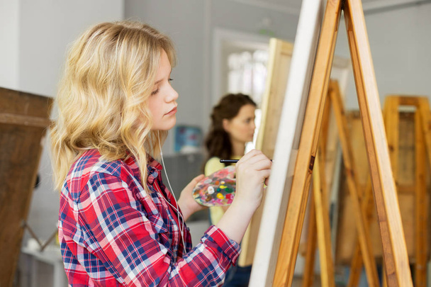girl with easel painting at art school studio - Fotoğraf, Görsel