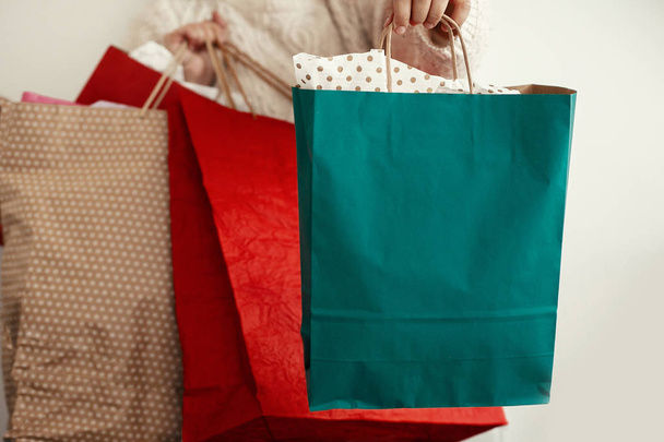 Weihnachtseinkäufe und Saisonverkauf. glückliches Mädchen mit bunten Einkaufstaschen auf weißem Hintergrund. Weihnachtsgeschäft. Raum für Text. Schwarzer Freitag. Cyber-Montag - Foto, Bild