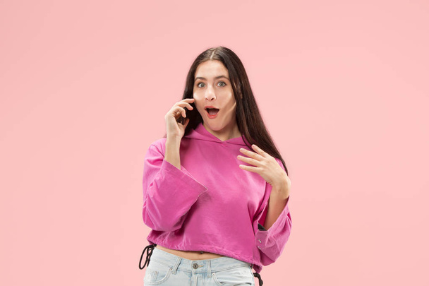 Mujer hermosa joven usando estudio de teléfono móvil sobre fondo de color rosa
 - Foto, Imagen