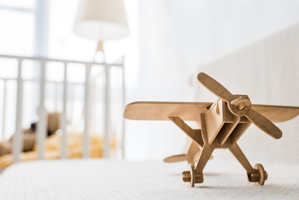 avión de juguete de madera retro en el sofá en la habitación del vivero
 - Foto, Imagen