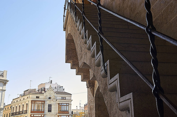 Жюри Валенсии доверило строительство башен маэстро Пере Балагеру, вдохновлённому другими готическими дверями, с многоугольными башнями, такими как Poblet monastery 's Puerta Real, под влиянием генуэзского архитектурного стиля, или
 - Фото, изображение