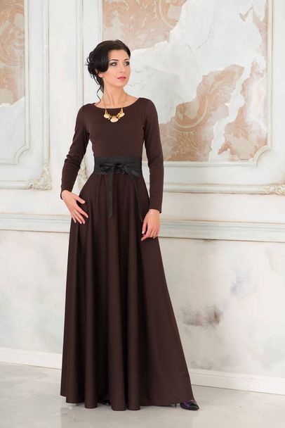 Brunette woman in elegant brown dress posing in vintage interior  - Foto, imagen