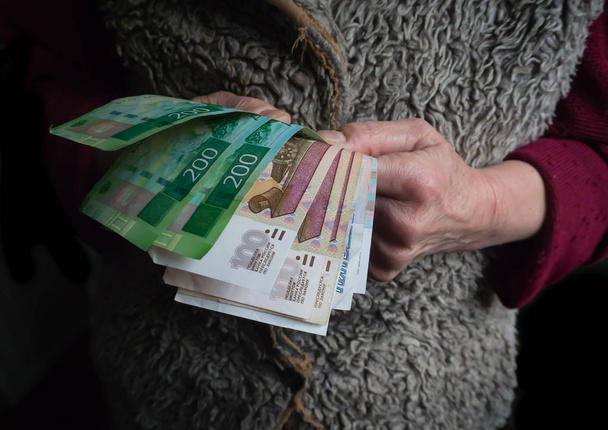 zog sich mit russischen Rubel in der Hand zurück. das Konzept der sozialen Sicherheit. - Foto, Bild
