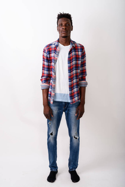 白に対して立っている若い黒人アフリカ男性の全身ショット - 写真・画像