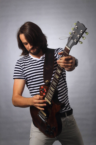 рок-музыкант играет соло на гитаре.фото на заднем плане
 - Фото, изображение