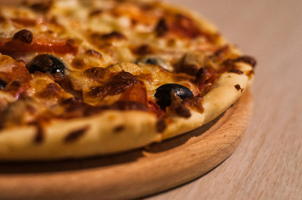 kotitekoinen kuuma pizza puinen leikkuulauta, lähikuva
   - Valokuva, kuva