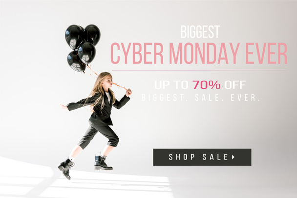 fashionable child in trendy suit jumping with black balloons on grey, black friday sale banner - Foto, Imagem