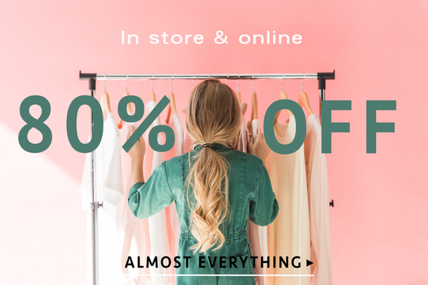 rear view of blonde kid in trendy overalls choosing clothes on hangers, sale banner concept - Photo, image