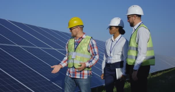 Elektrische werknemers lopen op een zonne-boerderij - Video