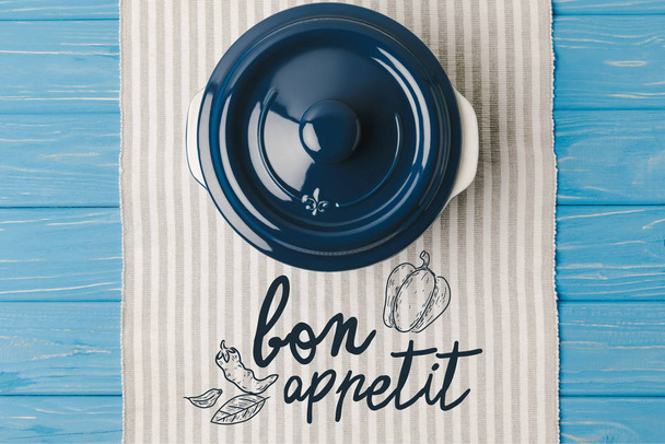top view of pan on napkin on blue wooden table, bon appetit lettering - Photo, Image