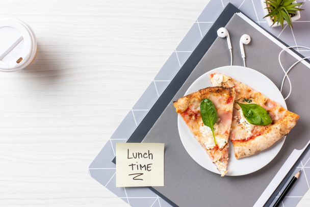 昼食時、イヤホンとテーブルの上のピザの碑文と付箋の平面図 - 写真・画像
