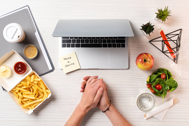 частичный вид сверху женских рук, ноутбук, записка с надписью сделать выбор и здоровую пищу с нездоровой пищи на рабочем месте
  - Фото, изображение