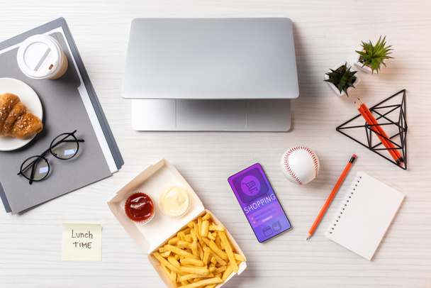 a francia krumplit, Öntapadó jegyzet felirat ebéddel, felülnézet laptop és okostelefon alkalmazását a munkahelyen - Fotó, kép