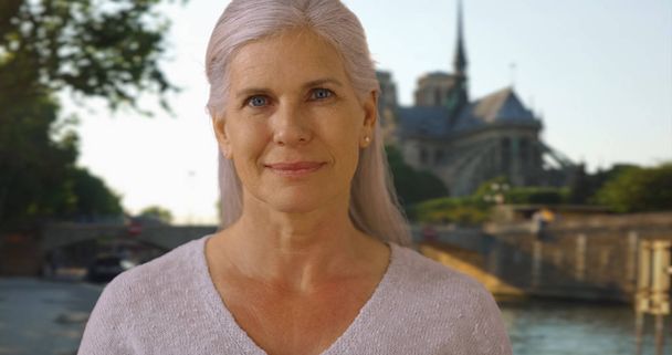 Casual portrait of happy smiling mature woman near Notre Dame cathedral - Valokuva, kuva