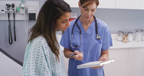Close-up portrait of medical nurse checking medical history with patient - Photo, Image