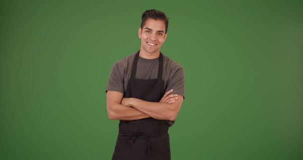 Happy handsome young Latino restaurant employee on green screen - Fotografie, Obrázek