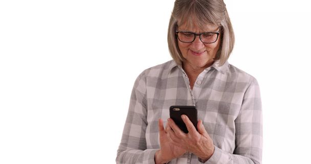 Charmante vieille dame utilisant smartphone pour communiquer sur fond blanc
 - Photo, image