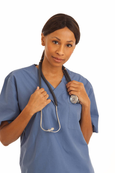 Close up of smiling black doctor wearing scrubs on white background - Photo, Image