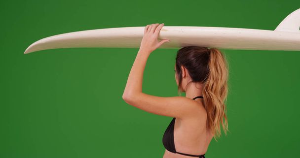 Fiatal fehér szörfös lány, bikini zöld képernyő a szörfdeszka - Fotó, kép