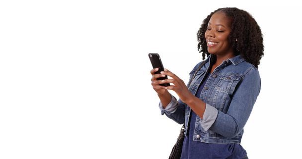 Pretty black woman smiles at cute text from boyfriend on white background - Fotografie, Obrázek