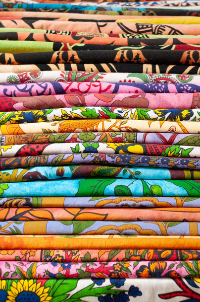 Hromadu barevných tkanin k prodeji na trhu, Bologna, Itálie. Květinovými vzory patchwork bavlněné "cotonine" - Fotografie, Obrázek