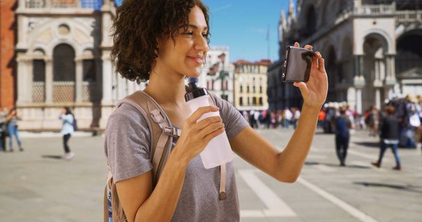 Pretty African female on vacation takes a selfie in St Marks square  - Fotó, kép
