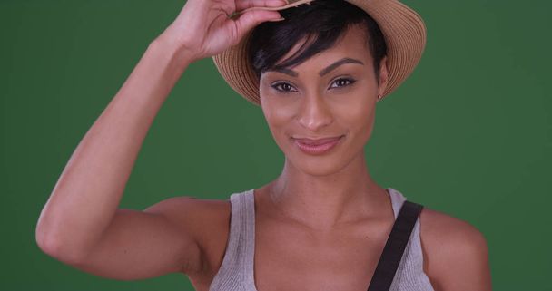 Happy smiling black woman holding hat on green screen - Photo, Image