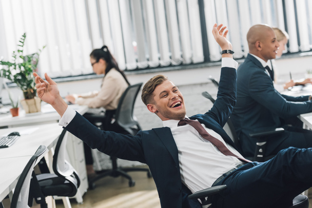 excited young businessman triumphing while working in open space  office - Photo, Image