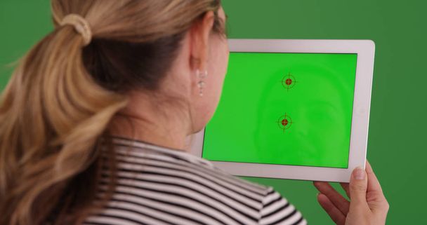 Λευκή γυναίκα χρησιμοποιώντας tablet με chroma κλειδί στην οθόνη την πράσινη οθόνη - Φωτογραφία, εικόνα