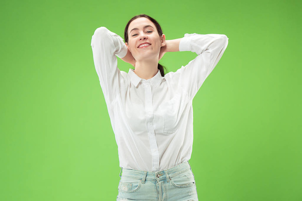 The happy business woman standing and smiling against green background. - Foto, imagen