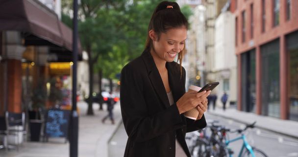 Messagerie texte femme d'affaires à l'extérieur du café dans la ville sur téléphone mobile
 - Photo, image
